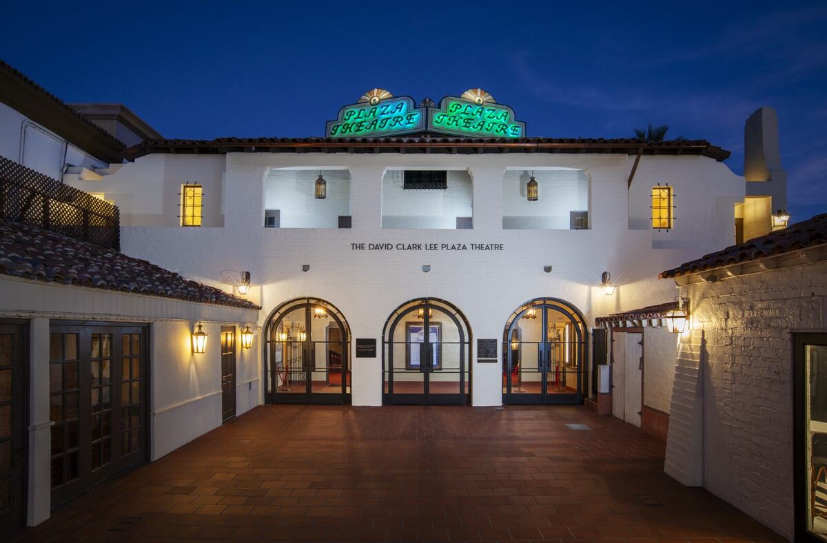 Restored Plaza Theatre exterior at dusk with illuminated neon signage and period-style exterior lighting