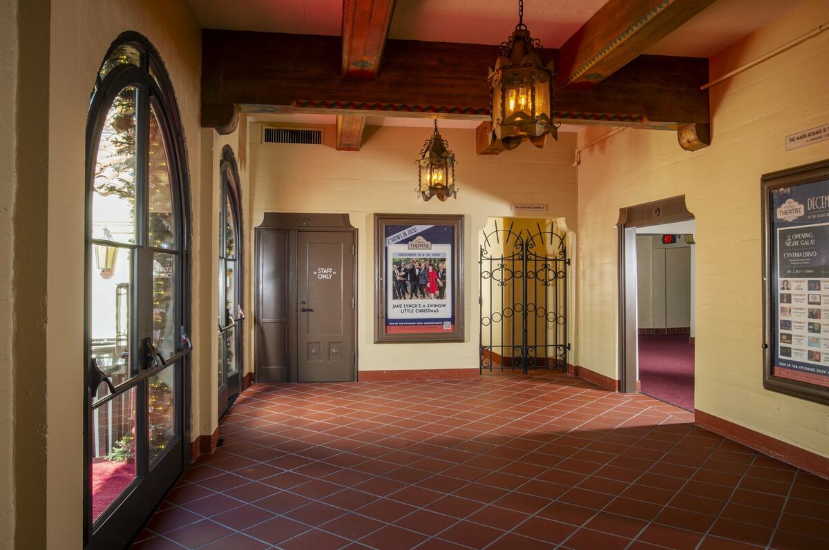 Restored Plaza Theatre lobby with period-correct hanging lanterns and architectural lighting